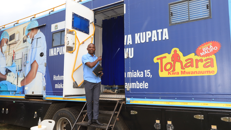 Afya Plus programme Joel Andwilege gives explanation on what normally takes place inside voluntary medical male circumcision mobile vans. He was briefing journalists attending a two-day media tour in Kahama, Shinyanga Region, at the weekend. 
