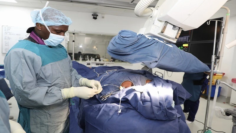 Yona Gandye, a cardiologist with Dar es Salaam’s Jakaya Kikwete Cardiac Institute, performs surgery on a patient who was recently found with a heart condition during screening at a health camp in Kagera Region