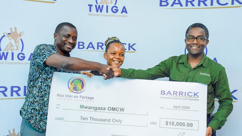 Barrick Tanzania Country Manager Melkiory Ngido (R) presents a dummy cheque for 10,000 US dollars to Mwangaza-OMCW chairman Marshalo Chikoleka in Dar es Salaam at the weekend.