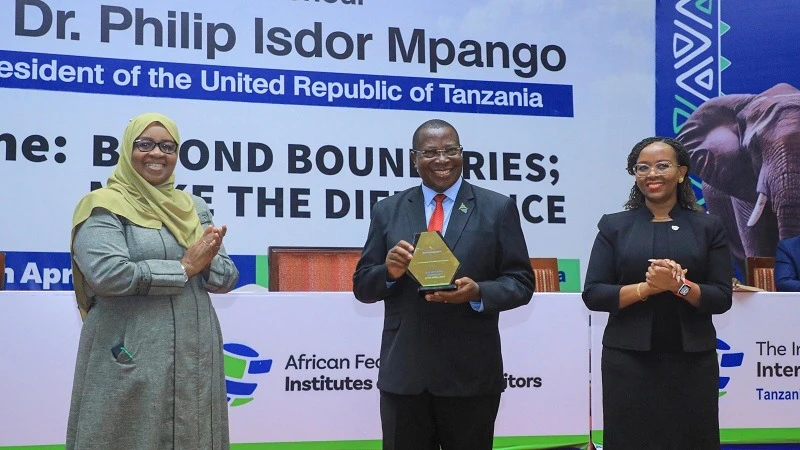 Vice President Dr Philip Mpango shows an award by the African Federation of Institutes of Internal Auditors (AFIIA) shortly after opening the 10th AFIIA general meeting in Arusha yesterday. Left is Zanzibar Minister for Finance and Planning.