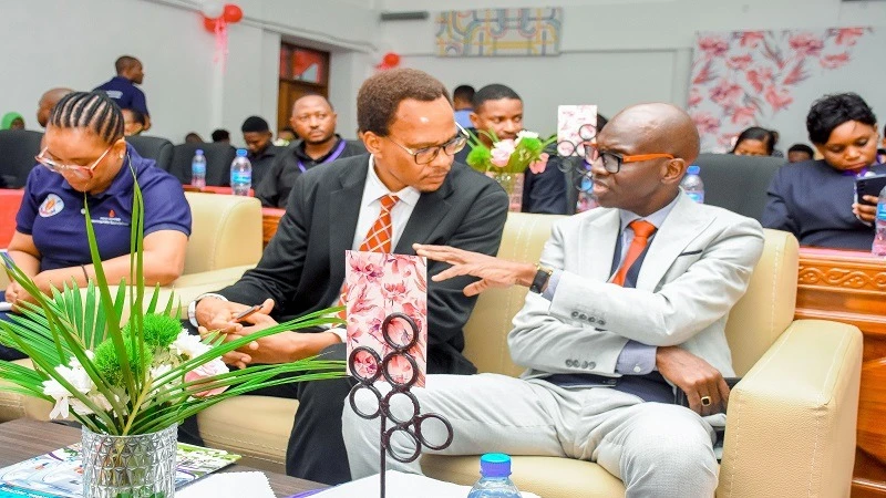 Prof Mohammed Janabi, the Executive Director  of Muhimbili National Hospital (MNH) speaks to  Dr Hamad Nyembea, the Director of Curative Services from the Ministry of Health during the Commemoration of World Haemophilia Day in Dar es Salaam yesterday. 