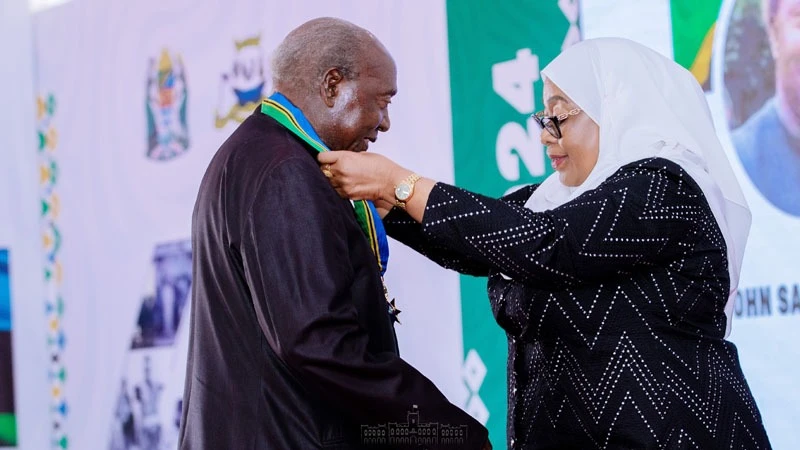 President Samia Suluhu Hassan awards the former First Vice President and Prime Minister, John Malecela second class Uhuru Torch medal at a Union anniversary ceremony at the Chamwino State House in Dodoma yesterday