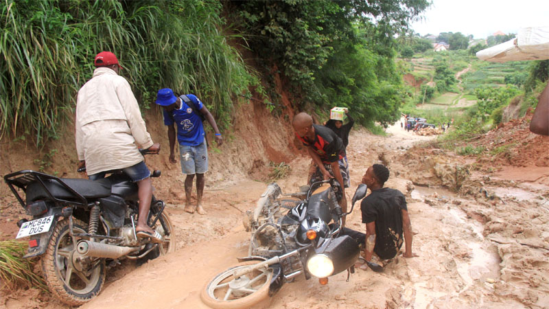A motorcyclist is seated helplessly after sliding along a muddy section of a road at Kiyombo Hill – Nyantira in suburban Dar es Salaam on Thursday. 
