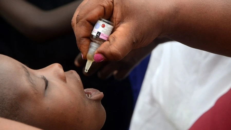 A health worker gives a dose of polio vaccine to a child during a door-to-door polio vaccination campaign in Kampala, Uganda