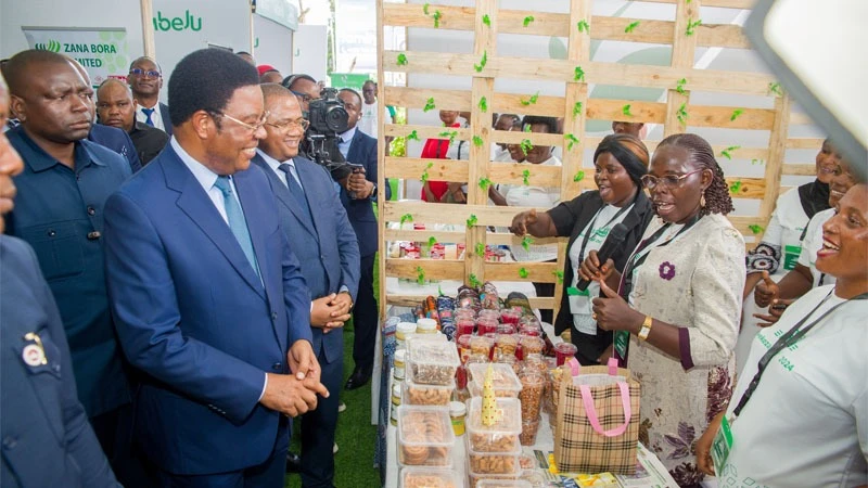 Semeni Gama (2nd-R), an official with a village community bank, briefs Prime Minister Kassim Majaliwa on the institution’s activities. The PM was on tour of various pavilions at an exhibition held in tandem with a seminar organised by CRDB Bank.