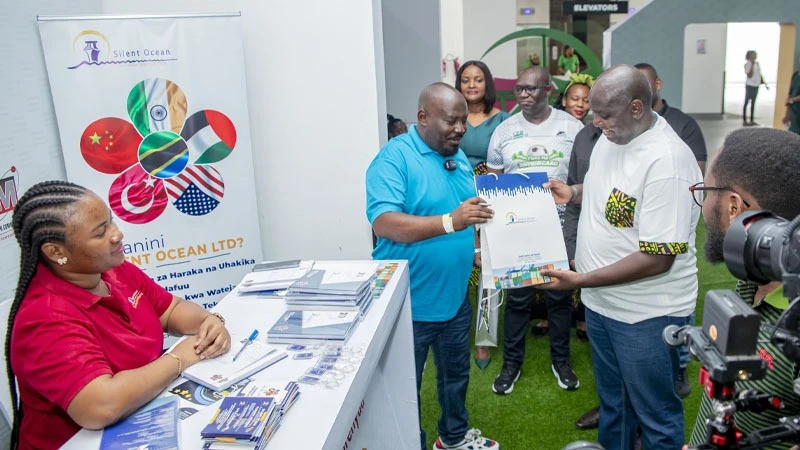 Boma Raballa, chief commercial officer, CRDB Bank ( R) receives a souvenior from Silent Ocean marketing manager Mohammed Kamilagwa during his visit at different entrepreneurs pavilions on the sideline of capacity building seminar  for online businesses.