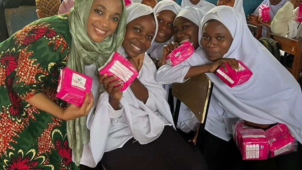 Asma Mwinyi Foundation director Asma Mwinyi (L) joins students on Pemba Island yesterday shortly after presenting them with sanitary pads. It has now reached a total of 30,000 students across Tanzania with the items. 