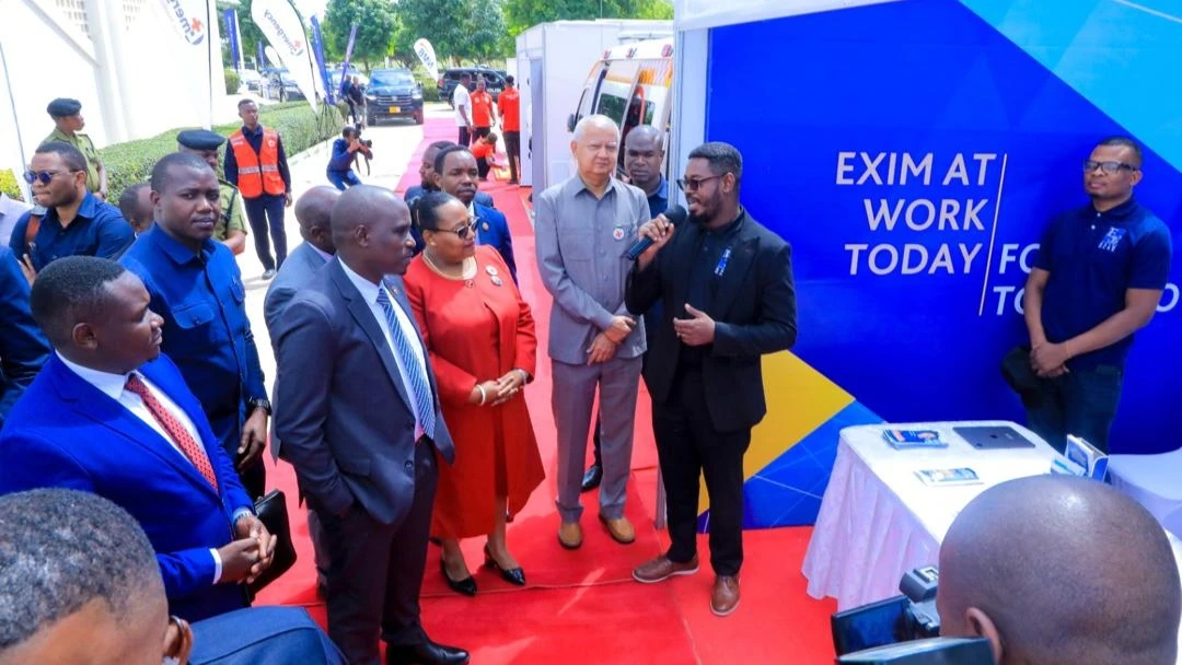 Stanley Kafu, the Head of Marketing and Communications at EXIM Bank, briefing Dr. Dotto Biteko (third from left), the Deputy Prime Minister and Minister of Energy, regarding the bank's initiatives during his visit to the Exim's booth.