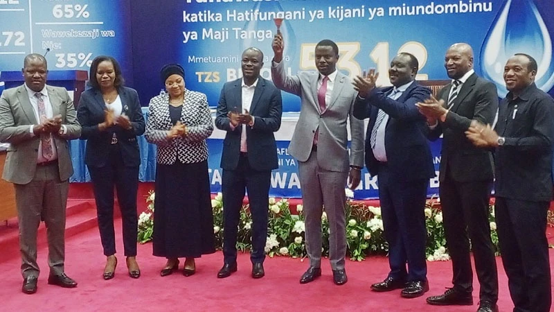 Minister for Works Innocent Bashungwa (4th R) rings the bell to officially signify the listing of Tanga Urban Water Supply and Sanitation Authority (Tanga UWASA) on the Dar es Salaam Stock Exchange at the Treasury Square in Dodoma yesterday.