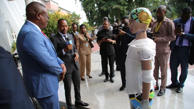 Information, Communications and Information Technology minister Nape Nnauye (L) has a ‘rare word’ yesterday with a robot installed at Parliament grounds in Dodoma city. 