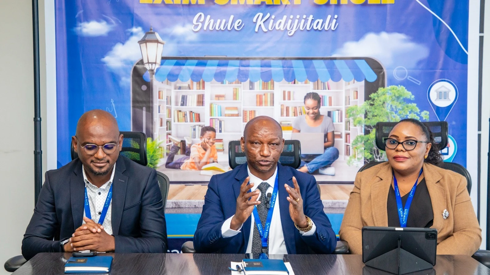 Eugen Massawe (center), the Head of Branch Operations at Exim Bank, introducing the bank's new digital platform known as 'Exim Smart Shule', Shule Kidijitali which enables parents or guardians to pay school fees for students digitally through the bank’s